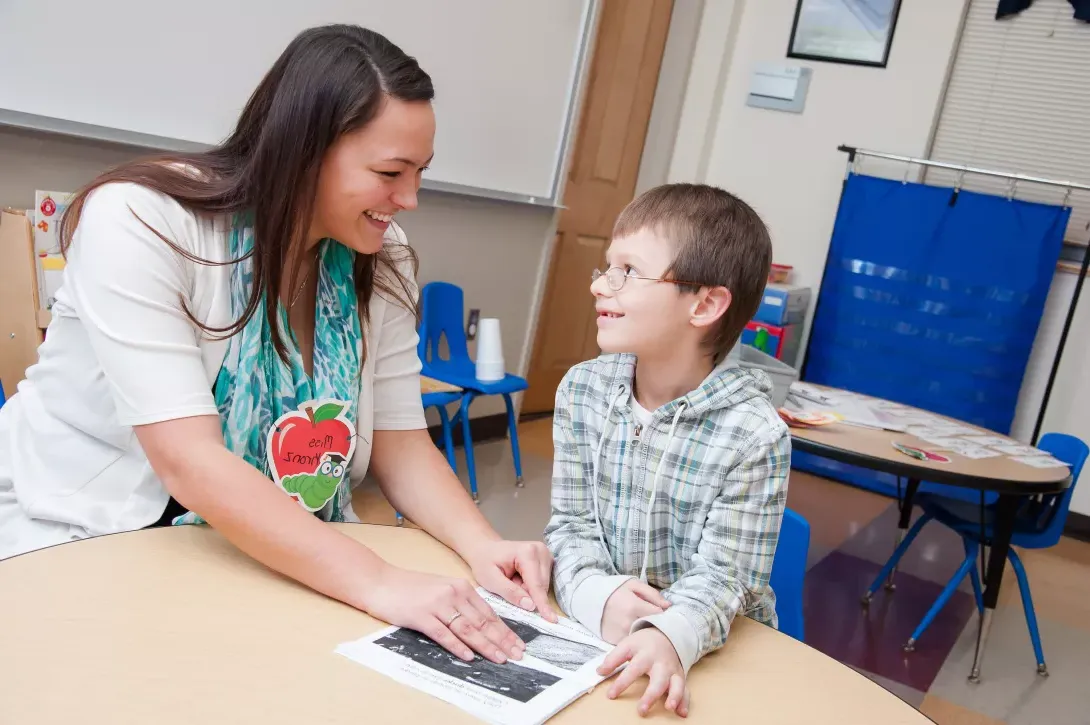 Student teacher working with student in classroom